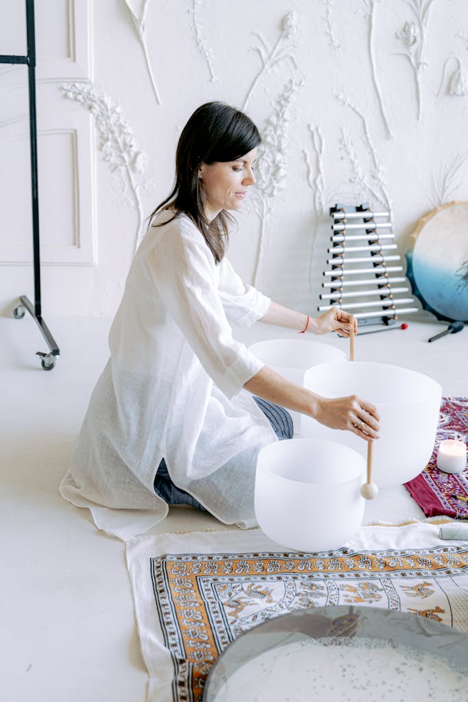 A serene scene of a woman performing a sound bath meditation indoors, focusing on relaxation and tranquility.