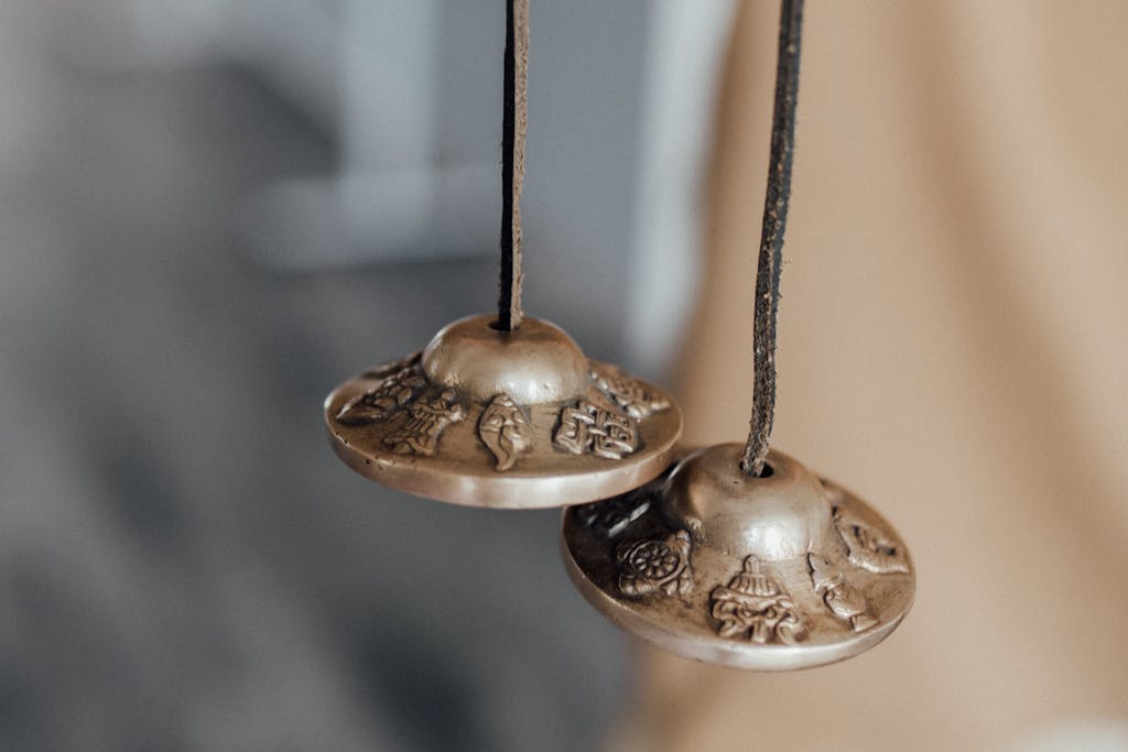 Detailed close-up of ornamented Tibetan tingsha bells used in spiritual practices.